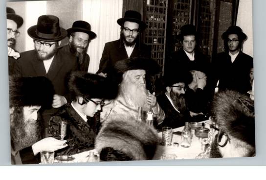 ה'אמרי חיים' מ'וויזניץ מימין, ה'אמשינאווער מברך על הכוס משמאל.