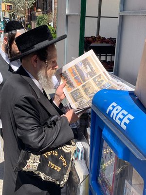 יצחק שטערן מעיין בתמונות העיתונים.jpg